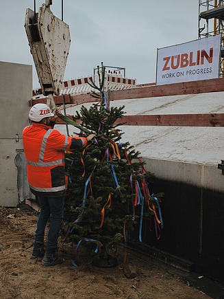 The decorated topping-out tree is raised. 
