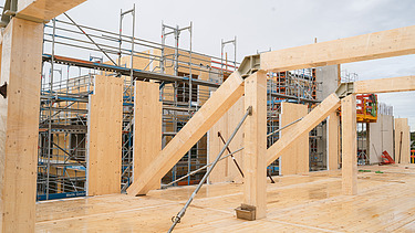 Foto der Uni Witten von außen. Man sieht die Montage der Brettschichtholzträger und Holzelemente.