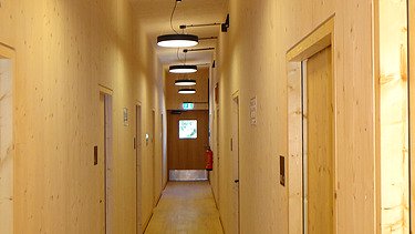 Foto der Höllentalangerhütte Grainau. Flurbereich mit vielen LENO-BSP-Holzwänden und sichtbaren Holzoberflächen.