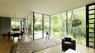 Foto eines modernen Bungalows mit LENO-BSP-Flachdach. Detailbild Wohnzimmer mit sichtbarer LENO-BSP-Decke.