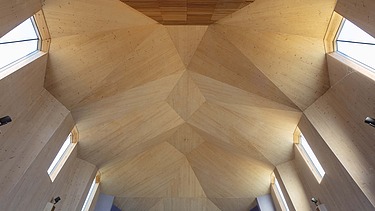 Foto eines Innenraums einer Kapelle mit großer gewölbter Holzdecke