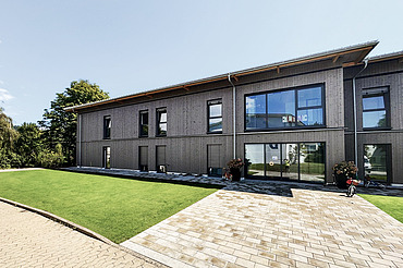 Photo of the parent-child house in Gailingen. You can see a building with a wooden façade.