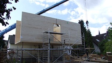 Photo of a timber house with flat roof during assembly. LENO-BSP.