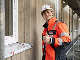Photo of Michael on the building site, with thumbs up. 