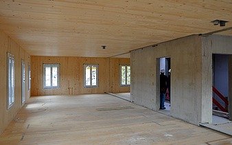 Photo of an interior shot of a multi-storey residential building under construction. You can see many wooden surfaces.