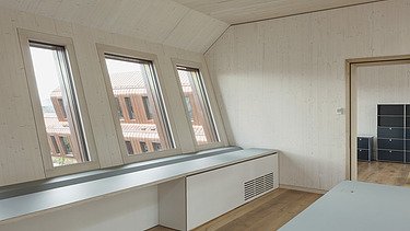 Interior photo with sloping wooden walls and wooden surfaces.