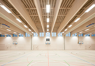 Foto der Sporthalle des Gymnasiums in Diedorf. Holzbau Halle innen.