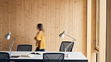 Photo of an interior of the Black and White office in London. You can see wooden surfaces and a woman.