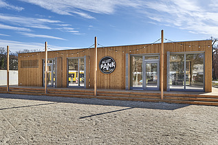 Photo of a wooden building with flat roof and terrace.