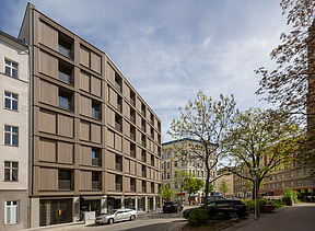 Photo of the multi-storey residential complex in Stendaler Strasse Berlin. You can see a tall building with a wooden façade.