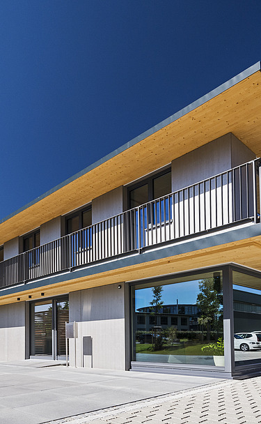 Foto der Anwaltskanzlei FGS Augsburg. Modernes Holzgebäude mit Flachdach.