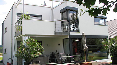 Foto eines kubischen Wohnhauses aus Holz mit Putzfassade. LENO-BSP.