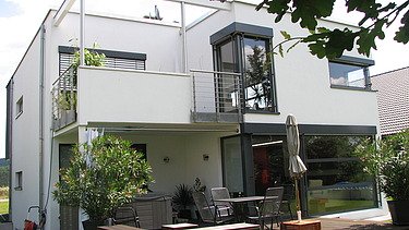 Photo of a cubic residential building made of wood with a plaster façade. LENO-BSP.