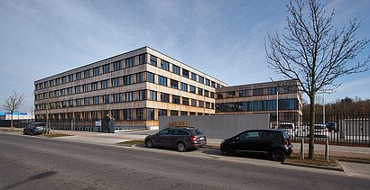 Foto des Bürogebäudes Flexim Berlin von außen. Zu sehen ist ein großes Gebäude aus Holz mit Holzfassade und Flachdach.