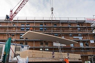 Photo of the Collegium Academicum in Heidelberg during assembly. You can see the unloading of large wooden elements.