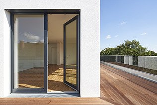 Foto eines Terrassenausschnittes einer Aufstockung mit Flachdach.