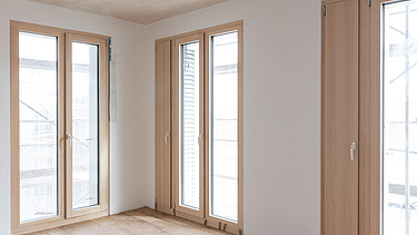 Foto eines leeren Wohnraumes, des Holzgebäudes CARL in Pforzheim. Man sieht viele Holzoberflächen.