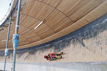 Oberhof luge track Photo of a toboggan run with wooden roofing and a reclining bobsledder