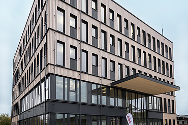 Foto eines mehrgeschossigen Holzbaugebäudes. Büroneubau T3 von ZÜBLIN Timber in Aichach.