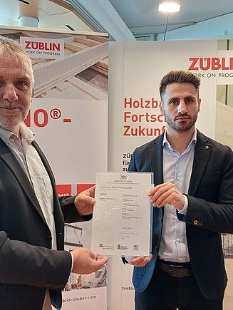Foto der ZÜBLIN Timber-Kollegen Martin Haller und Gabriel Petrus. Sie halten die Urkunde.