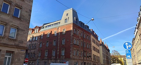 Photo of a wooden extension. You can see several tall buildings.
