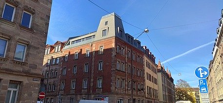 Photo of a wooden extension. You can see several tall buildings.