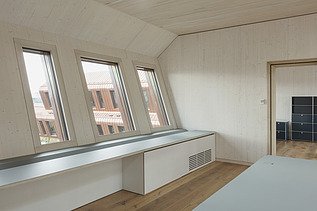 Interior photo with sloping wooden walls and wooden surfaces.
