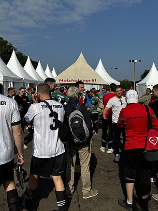 Foto von mehreren Fußballspieler:innen, die über das Gelände laufen.
