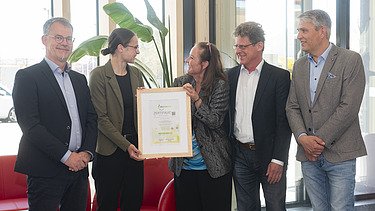 News ZÜBLIN Timber Photo with five people. Two are holding the Holz von Hier certificate for the new ZÜBLIN Timber office building.