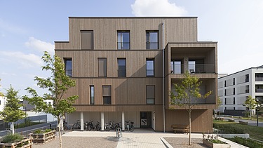 Photo of a multi-storey building made of wood and with a wooden façade.