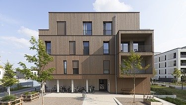 Photo of a multi-storey building made of wood and with a wooden façade.