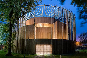 Elizabethan Theatre Condette Photo of the Elizabethan Theater in Condette France. You can see a round wooden building at night.
