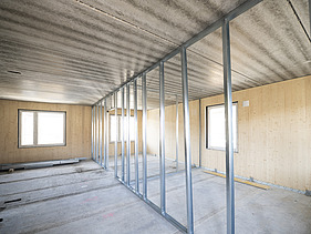 Photo of a building shell. You can see the wooden walls. 