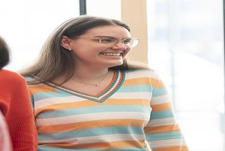 Photo of a young woman smiling at someone.