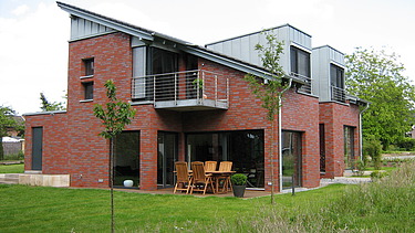 Foto eines Holzhauses mit Klinkerfassade. LENO-BSP.