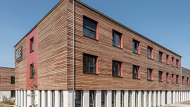 Foto einer Außenaufnahme eines Holzgebäudes mit Holzfassade.