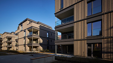 Photo of a multi-storey residential building with a wooden façade.