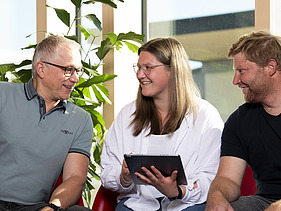 Foto von mehreren jungen Menschen, die sich besprechen. Ausbildung Industriekauffrau:man.
