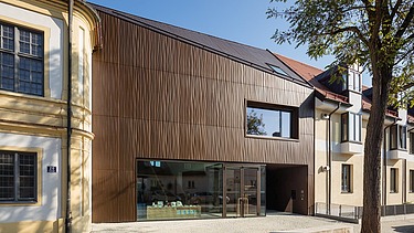 Foto eines Gebäudes aus Holz mit brauner Fassade.