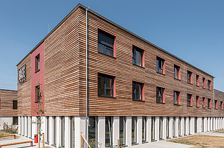 Foto einer Außenaufnahme eines Holzgebäudes mit Holzfassade.