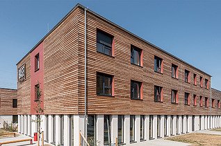 Foto einer Außenaufnahme eines Holzgebäudes mit Holzfassade.