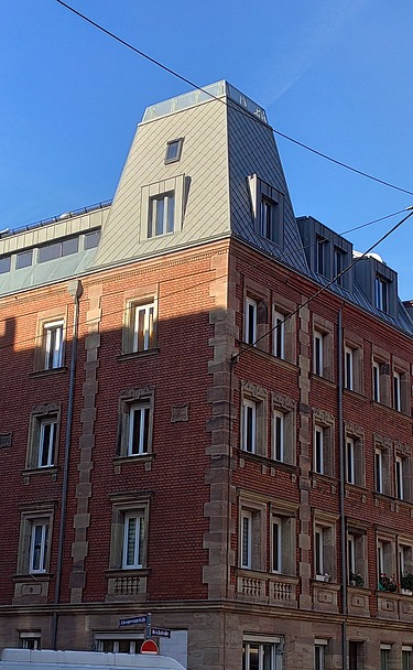 Foto einer Aufstockung aus Holz. Man sieht mehrere, hohe Gebäude.