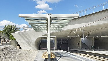 Photo of the Staatsgalerie stop in Stuttgart. You can see train tracks and concrete formwork and a covered waiting area.
