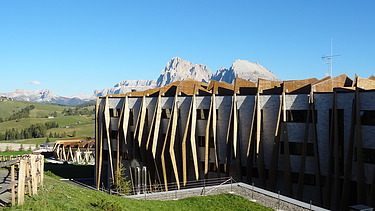 Foto des Hotels Alpina Dolomites Seiser Alm. Zu sehen ist ein Gebäude mit auffälligen Holzfassaden-Elementen aus FSH.