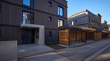 Photo of a multi-storey residential building with a wooden façade.