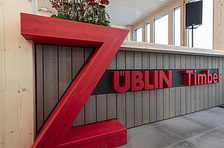 Foto eines Holztresens mit einem großen, roten Z darauf. bzw. dem Schriftzug ZÜBLIN Timber.