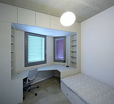 Photo of a room in the Adlershof student hall of residence in Berlin. You can see a bed and a desk.