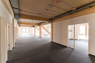 Photo of the inside of Witten University. You can see an interior with light-colored walls and a wooden ceiling