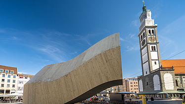Photo of the NEXT500 pavilion on Augsburg's market square. You can see a modern wooden building.