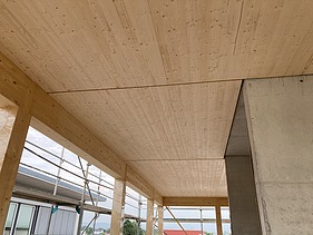 Foto eines Rohbaus aus Holz. Man sieht einen Innenraum mit Holzdecke.